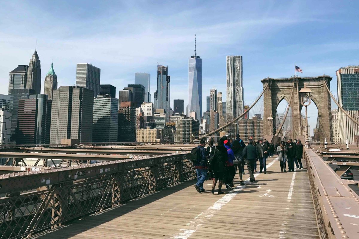 people walking across the Brooklyn bridge