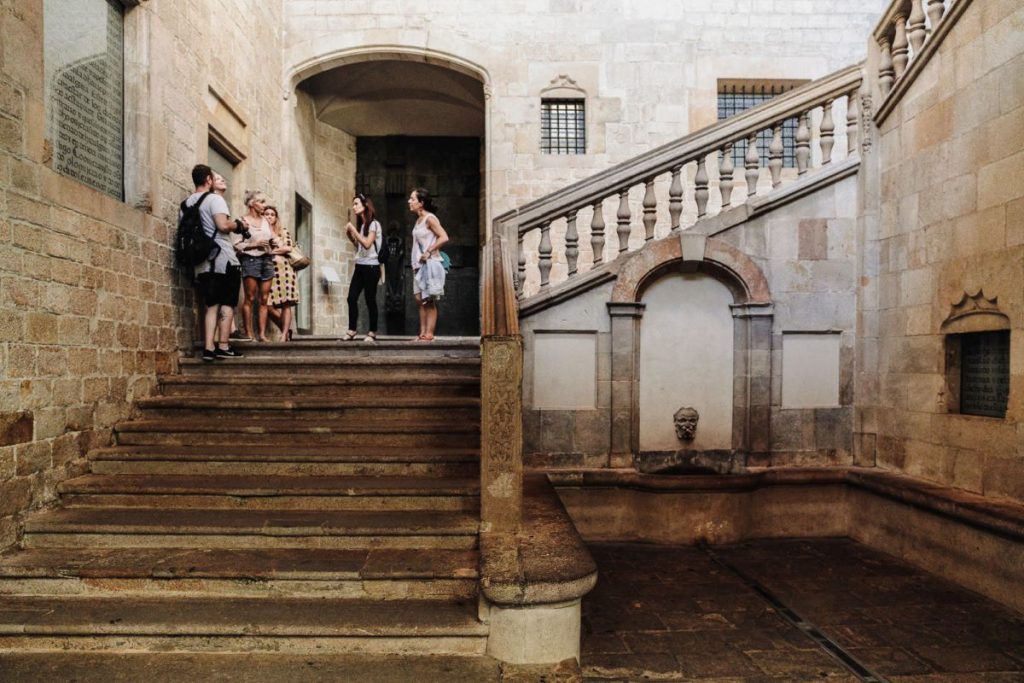 A group of people gather on the steps of Palau de Lloctinent in Barcelona