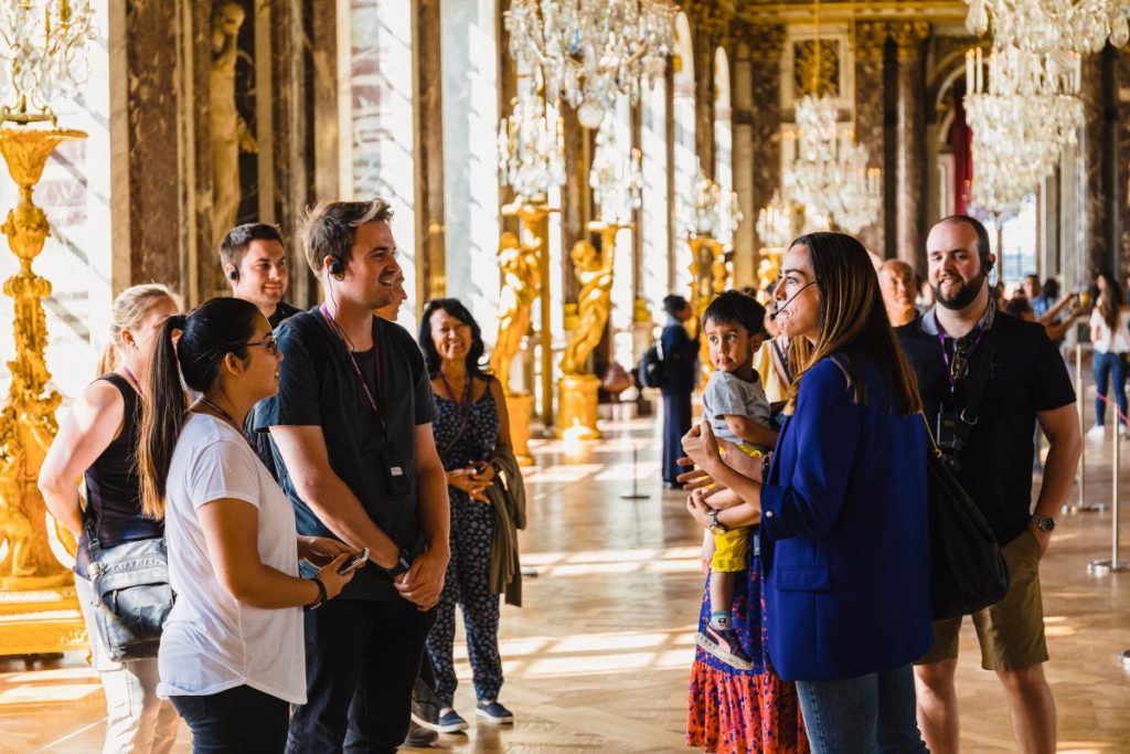 A group inside Versailles, being led by a guide