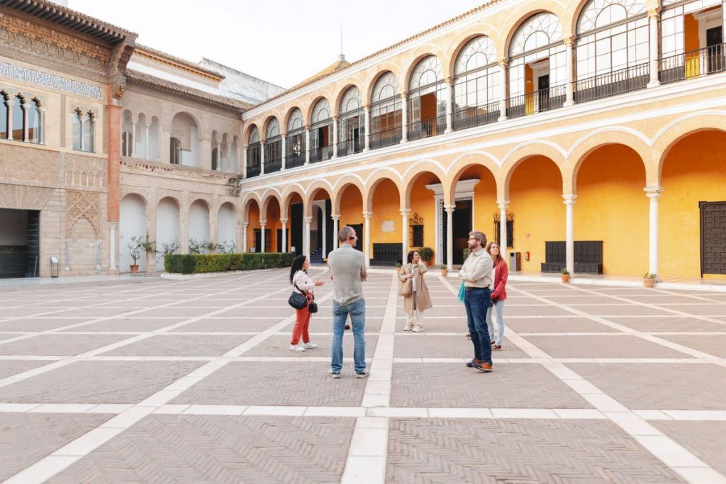 A group gathers inside the beautiful Royal Alcazar of Seville on a sunny day