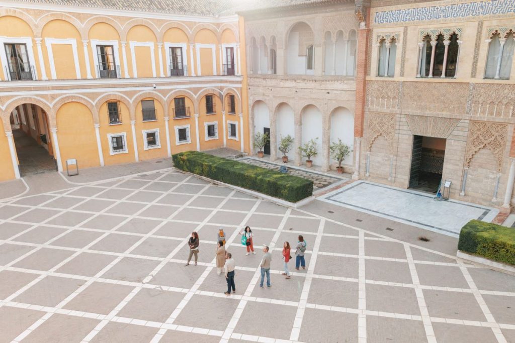 An aerial view of a guide leading a group through Seville’s Alcazar