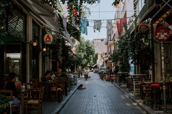 A quaint street in Athens lined with restaurants, with people dining and talking