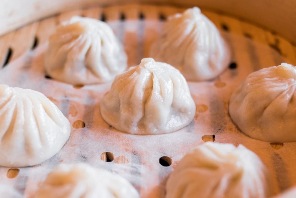 A bamboo steamer basket filled with dim sum dumplings.