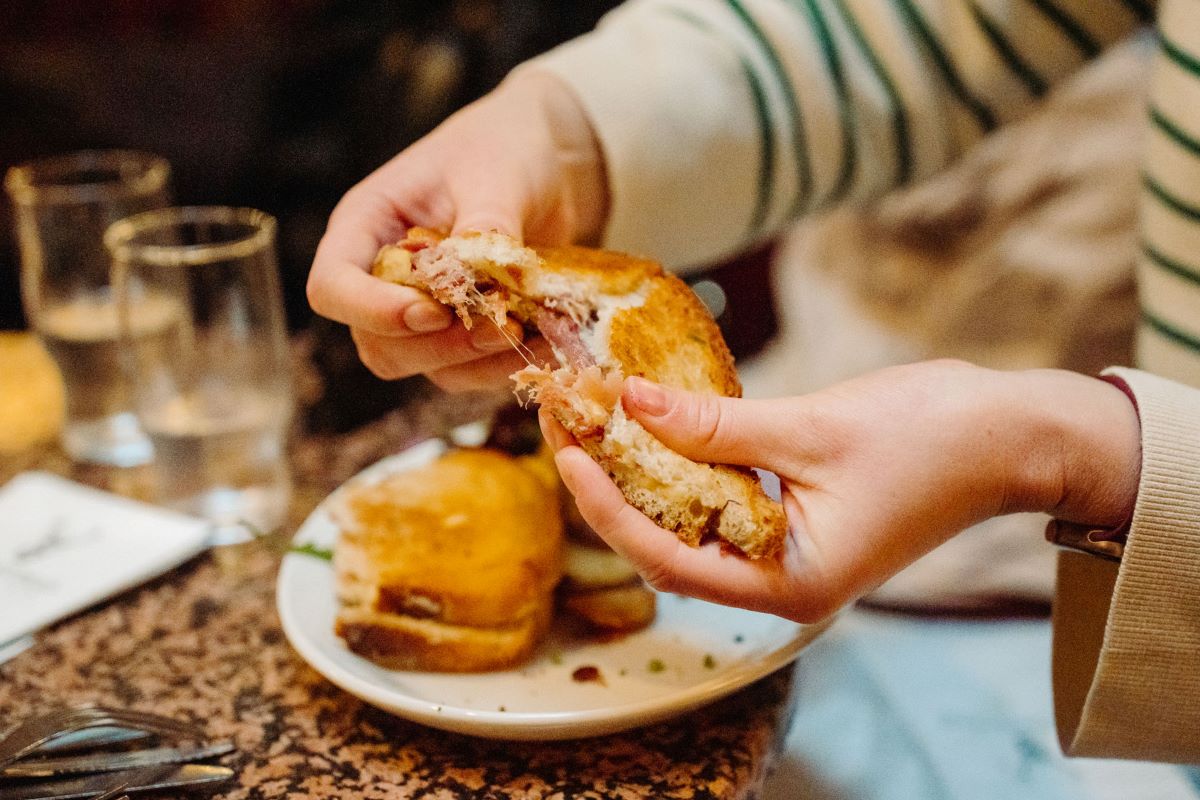 person pulling a sandwich apart