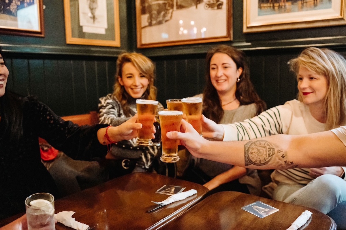 people doing a cheers with beer