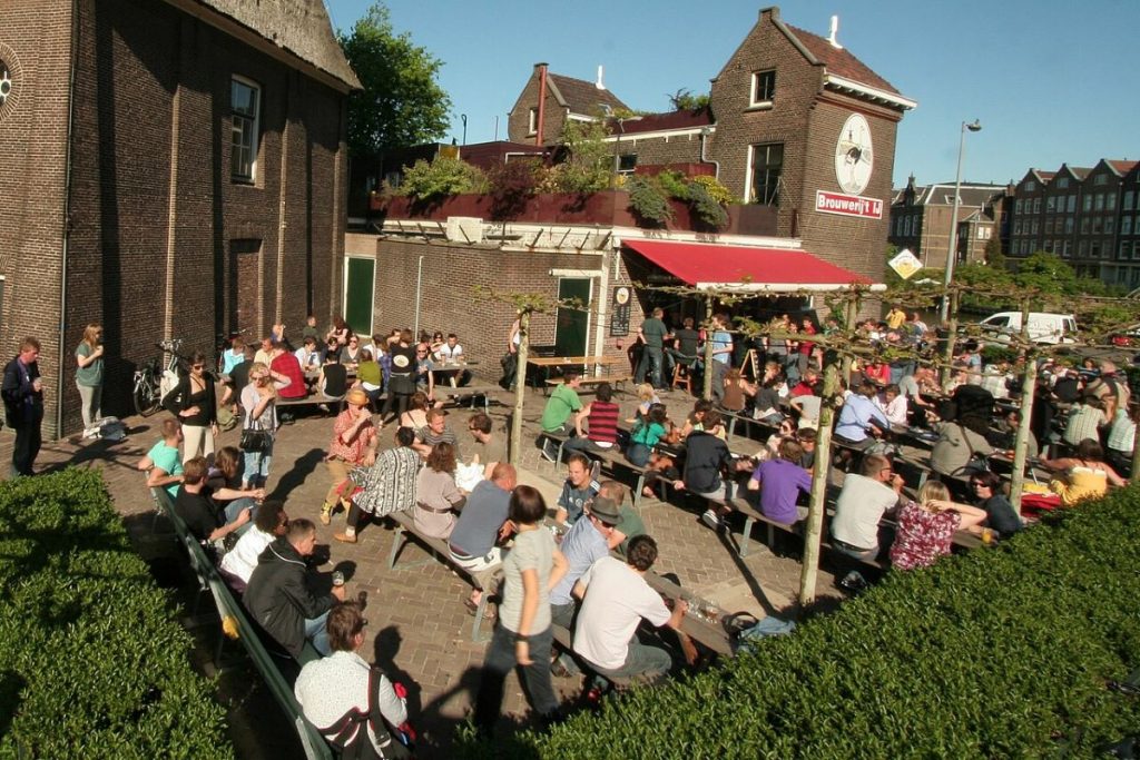 People sitting at a beer garden at Brouwerij 't IJ in Amsterdam.