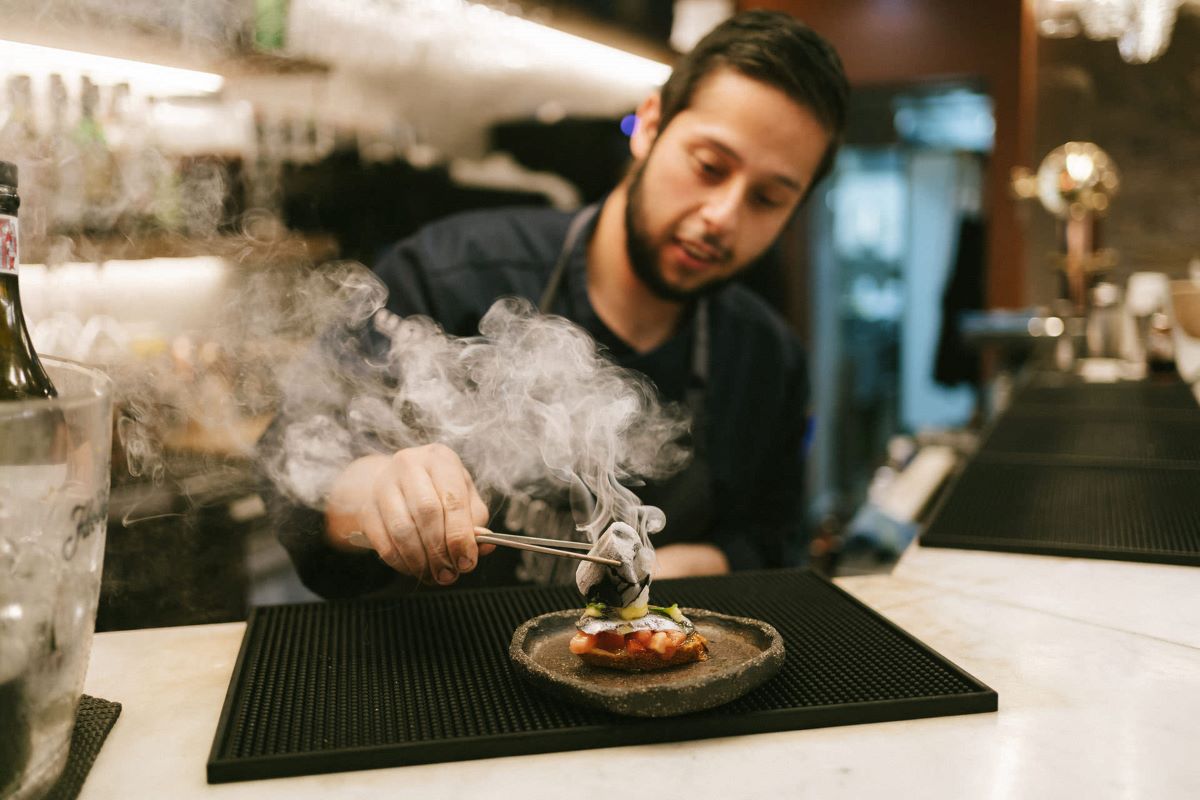 A chef plating a smoking pintxo in San Sebastian. 