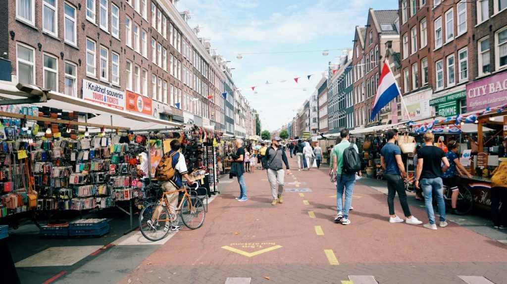 People walking around looking at shops at Albert Cuyp market in Amsterdam. 