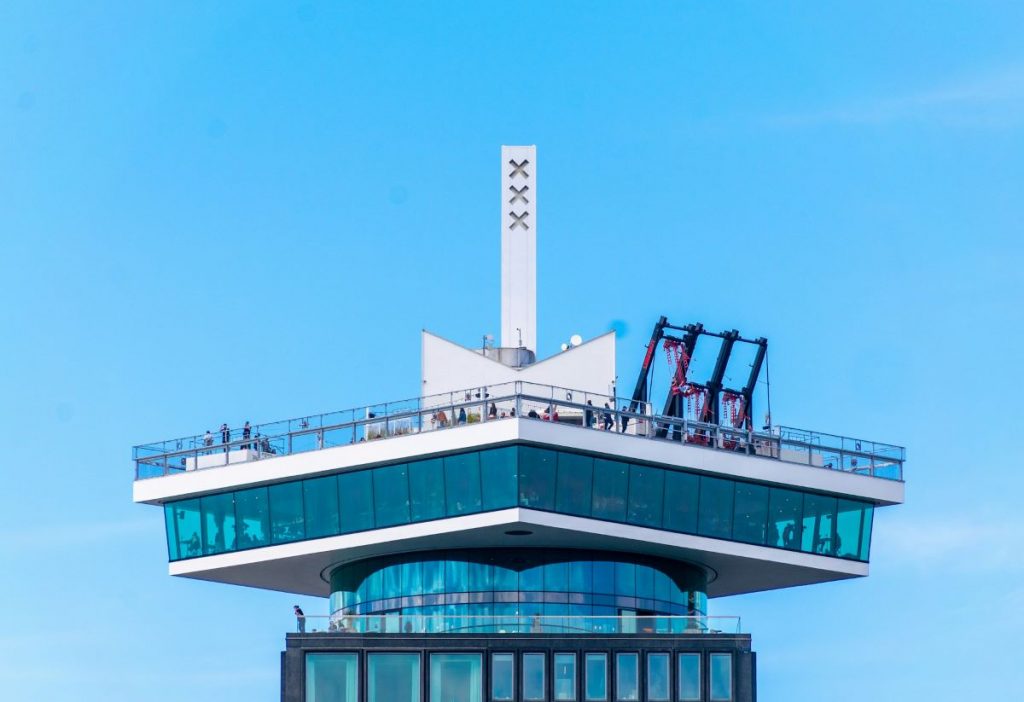 View of the A'DAM Tower roof where people are looking at the views of Amsterdam.