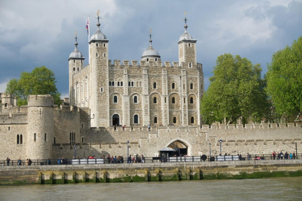 Large ancient building with four spires in front of a river