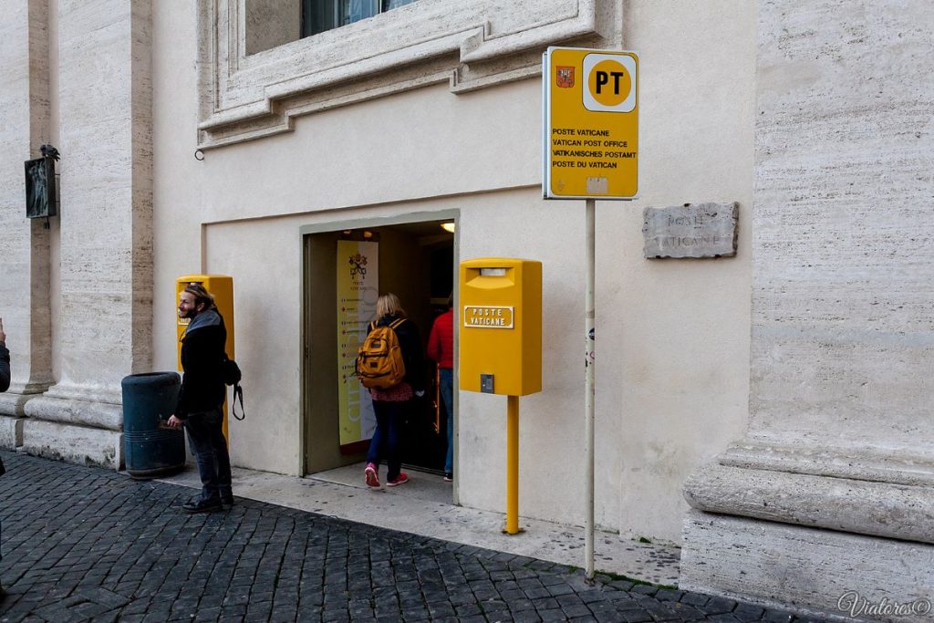 entrance to a white building with bright yellow post office box outside