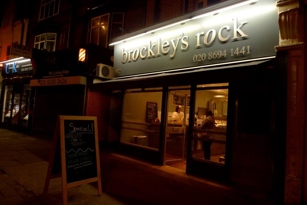 foto of restaurant with large glass windows and sign out front