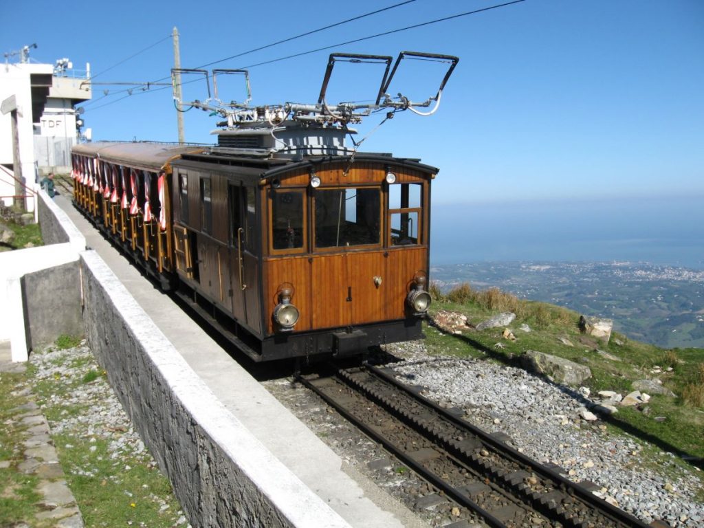 Wooden train on tracks with ocean in the background