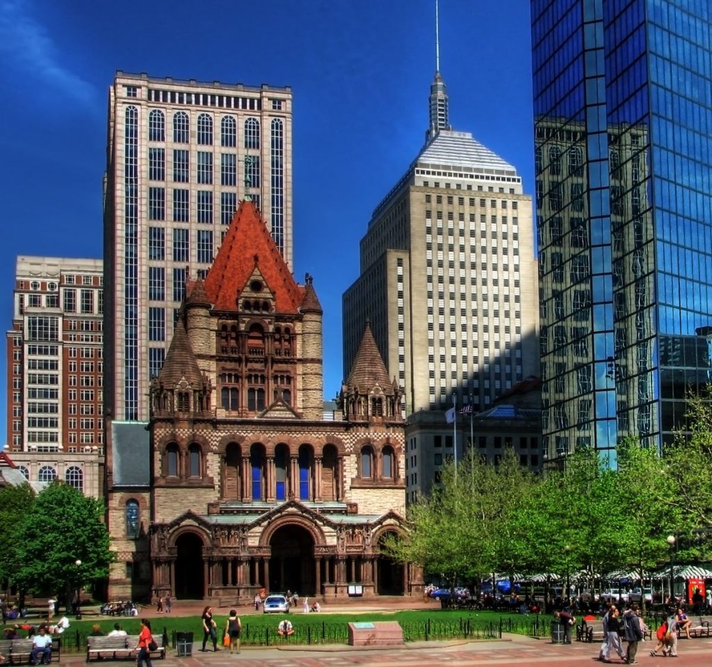historic church with red brick tower surrounded by modern buildings