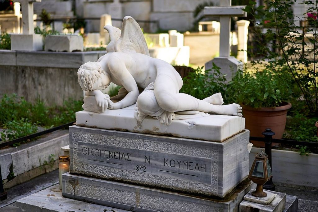 A mourning funerary winged male sculpture at the First Cemetery in Athens, Greece. 