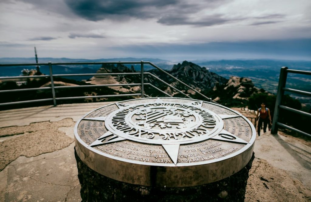 A compass at the top of a hiking trail in Montserrat, Spain. 