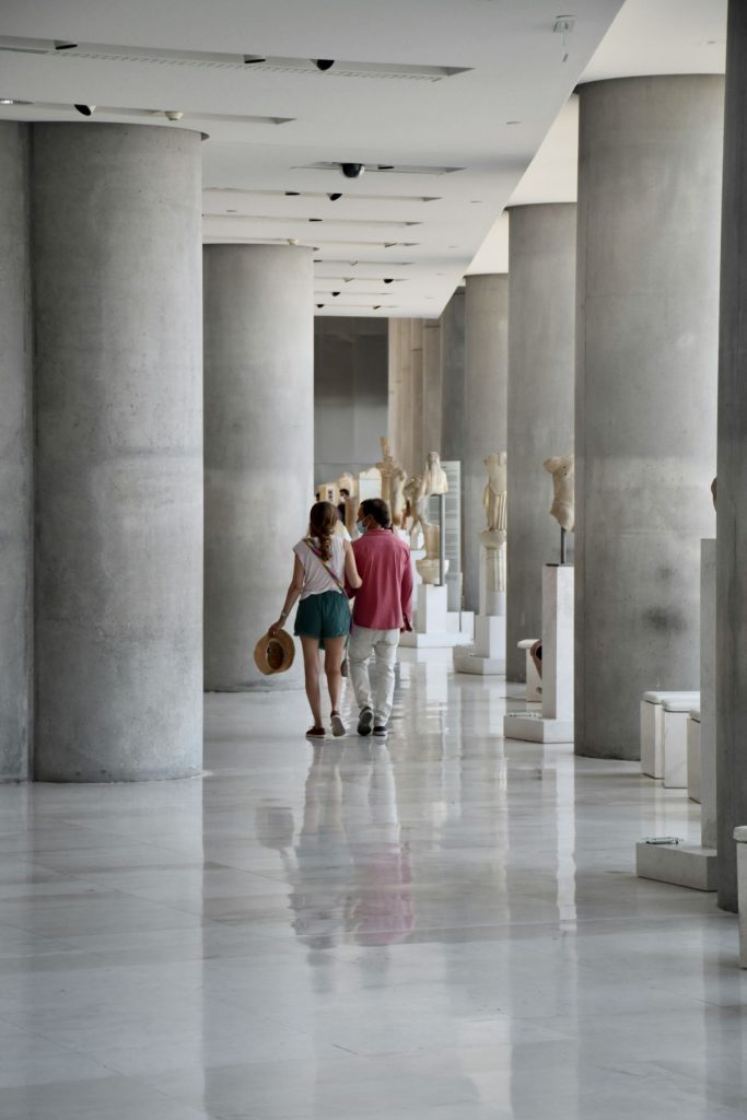 People walking down a corridor at the Acropolis Museum. 