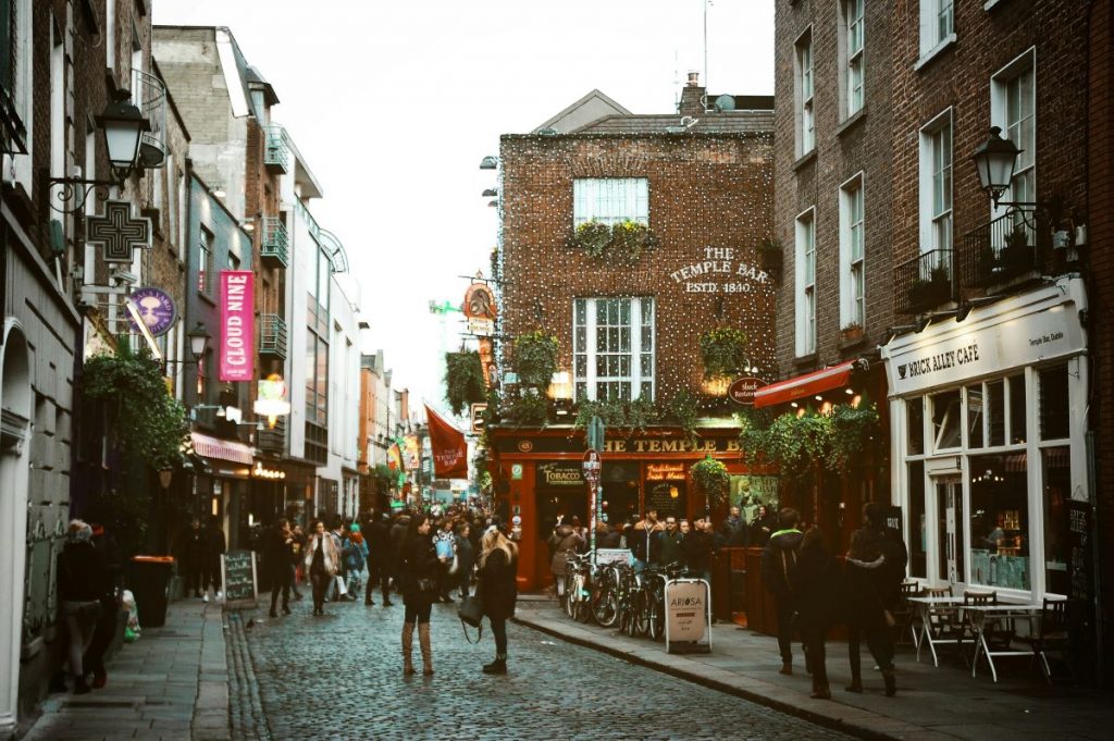 street scene with people walking in the street among pubs and restaurants