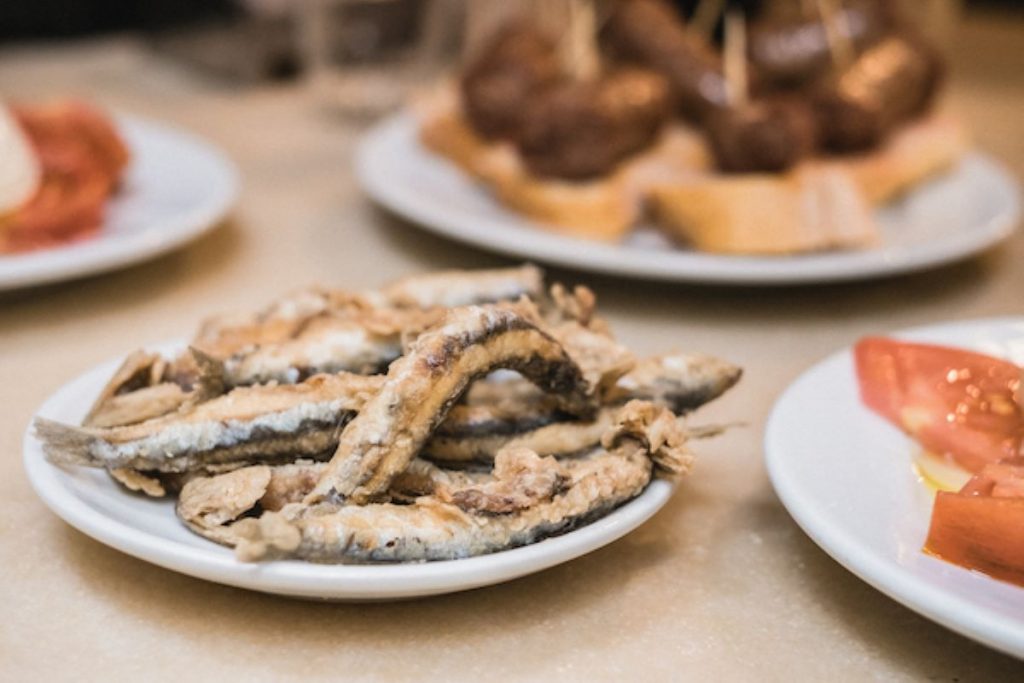 plates of tapas including sardines and tomatoes