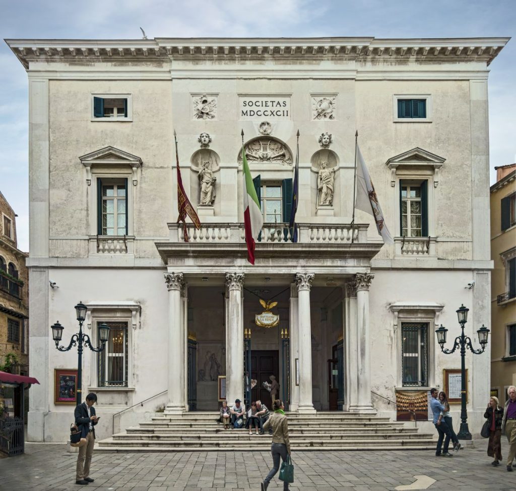 stairs leading up to large theater with columns in front of entrance