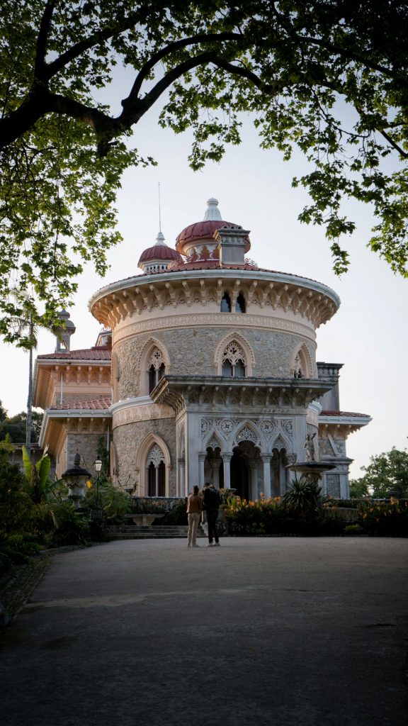 Two people walking to Palacio de Monserrate at sunset in Sintra, Portugal.