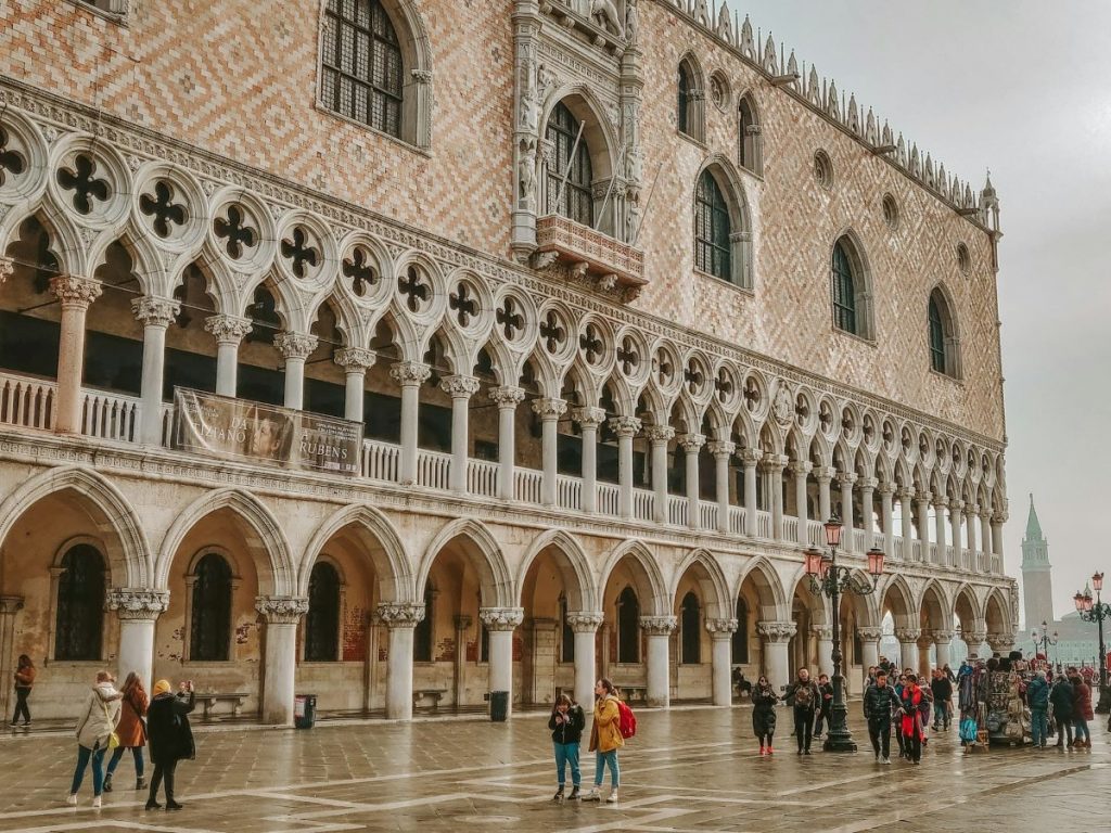 People standing outside of Doge's Palace taking photos and admiring the architecture 