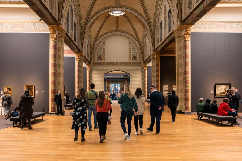 A group of people looking at rijksmuseum famous paintings.