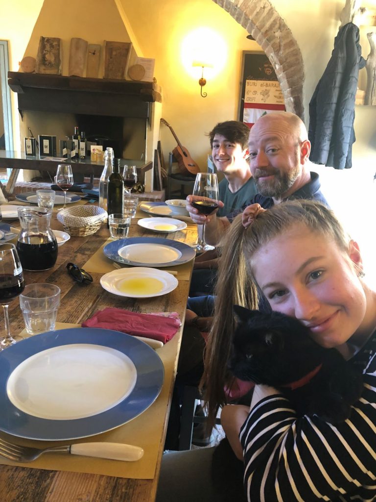 A family sitting together for lunch in Tuscany on a tour with Walks. 