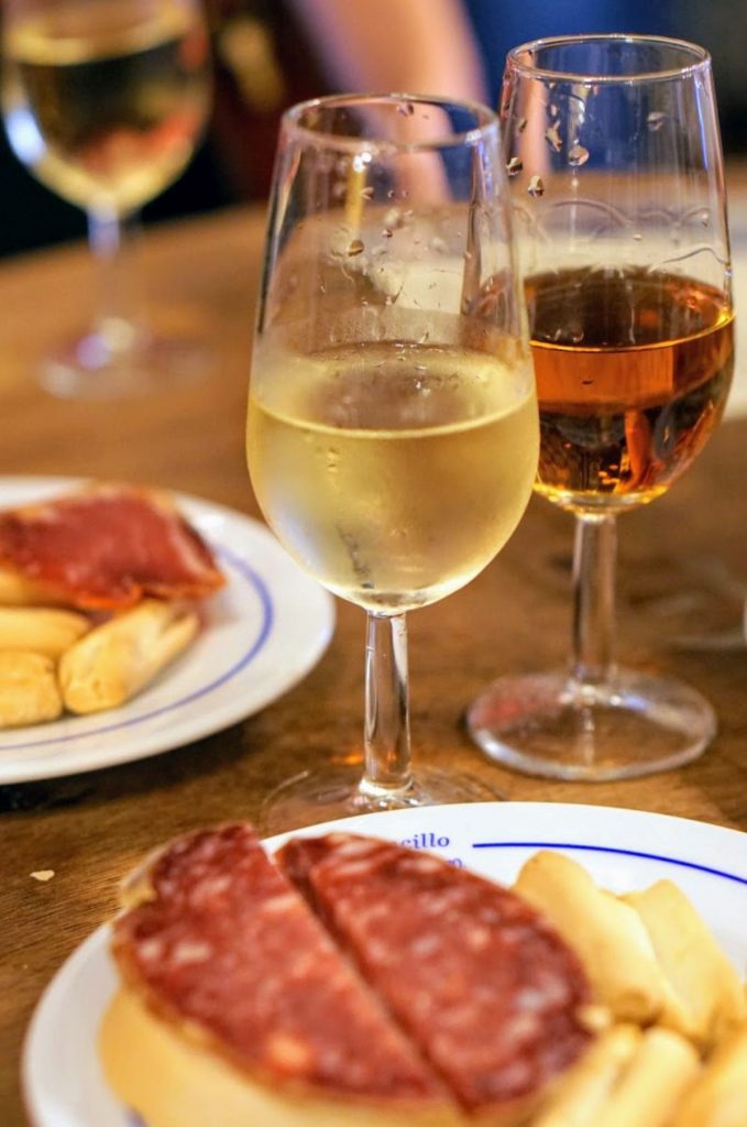 Two glasses of sherry wine and a tapa. 