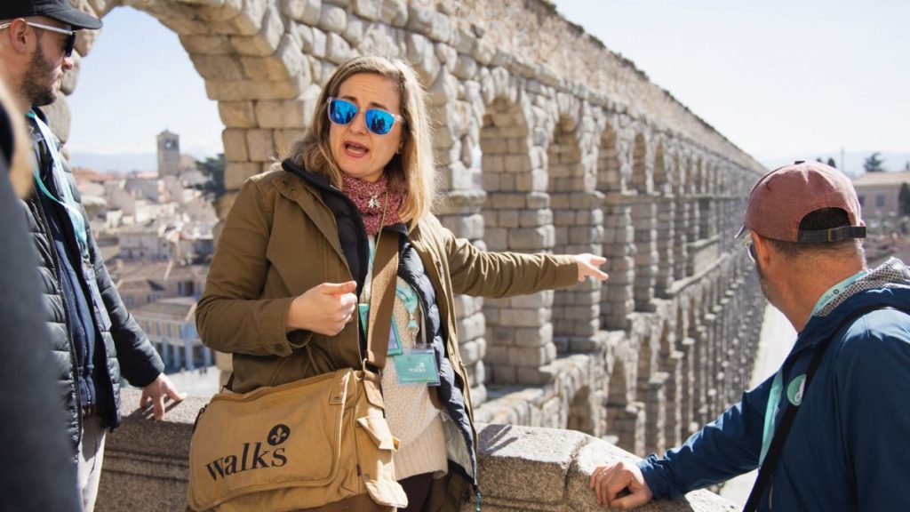 A tour guide explaining the aqueduct in Segovia. 