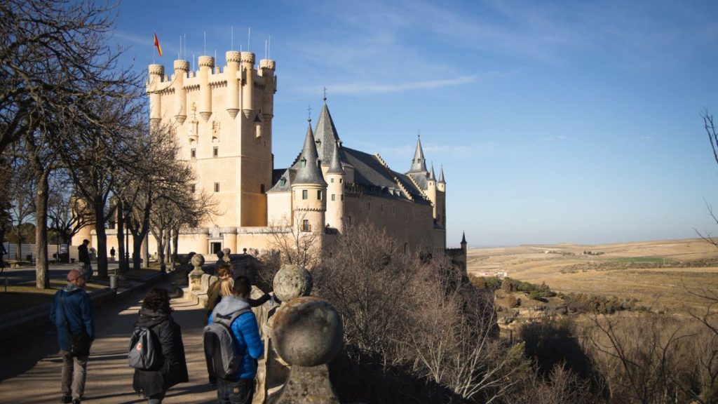 People walking to Segovia's medieval castle.