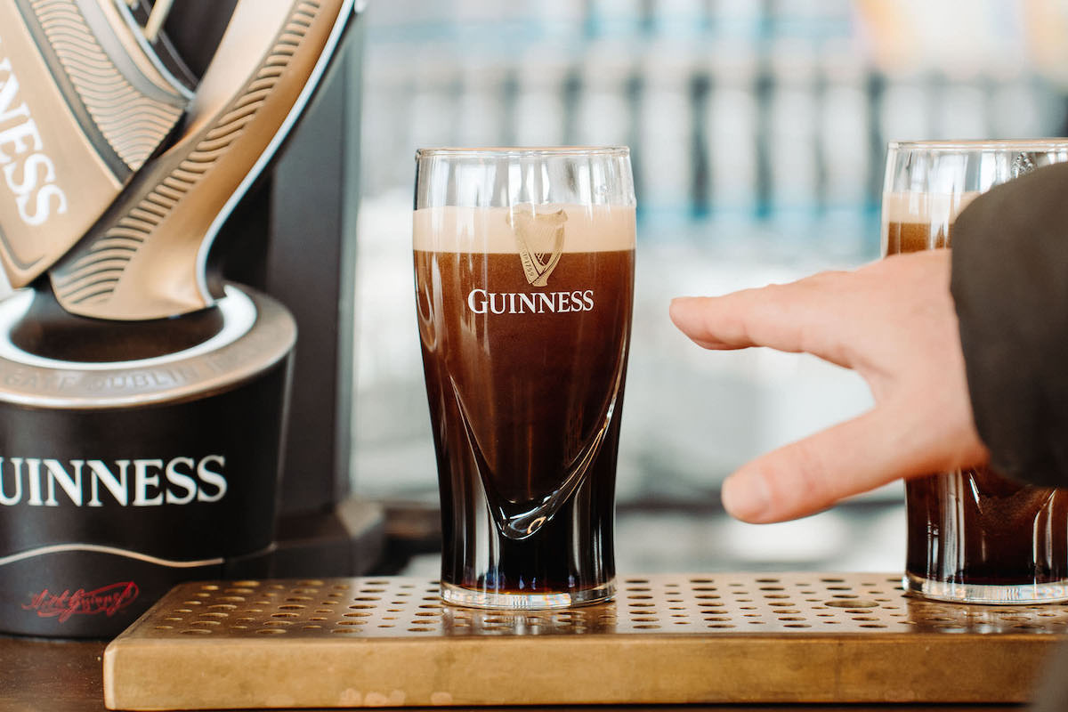 Hand reaching for a pint of Guinness beer