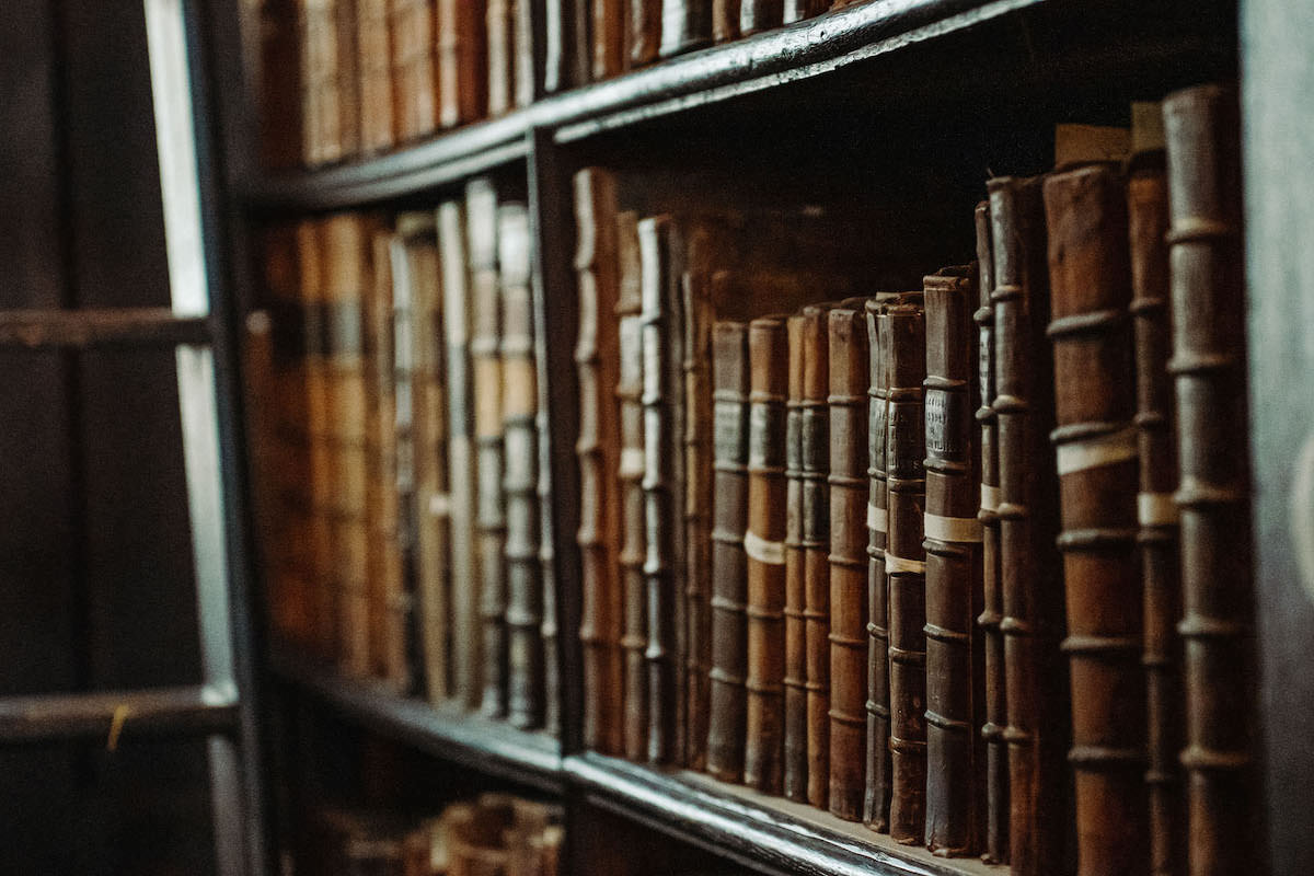 Old tomes of books on a shelf.