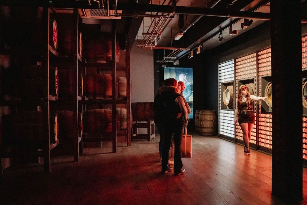 Group looking at whiskey casks in a distillery