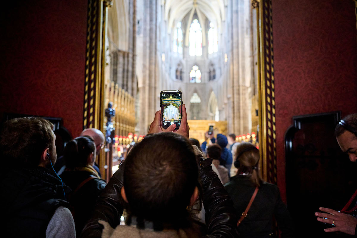 Person taking a picture of Westminster Abbey with his phone