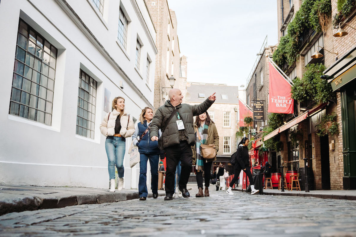 Tour guide walking by the Temple Bar in Dublin