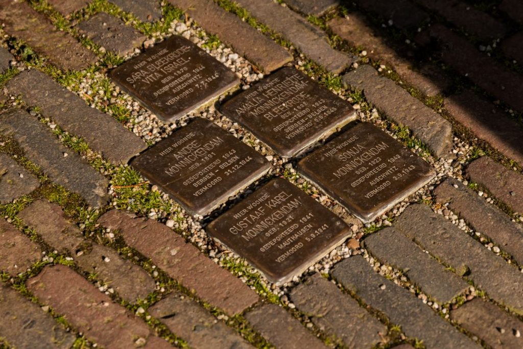 Bronze plaques on the ground in the Amsterdam Jewish Quarter with victims of the Holocaust's names.