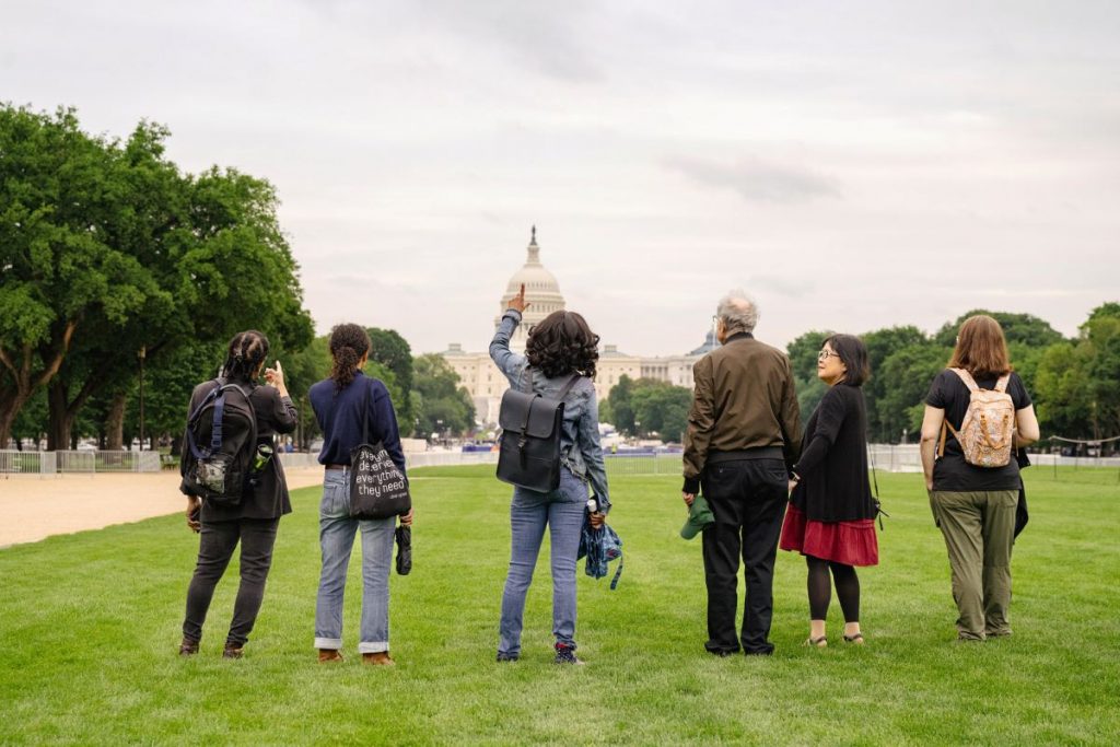 a group of people looking at a domed building in the background