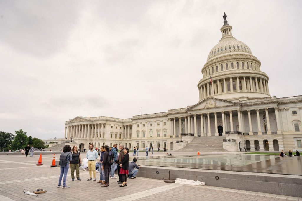 a group of people standing in front of a domed building