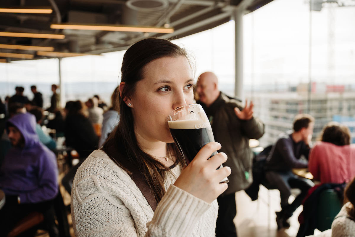 Woman drinking a pint of Guinness beer at the Brewery in Dublin