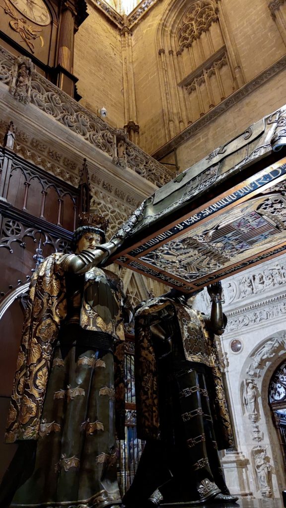 Two king statues holding Columbus's tomb. 