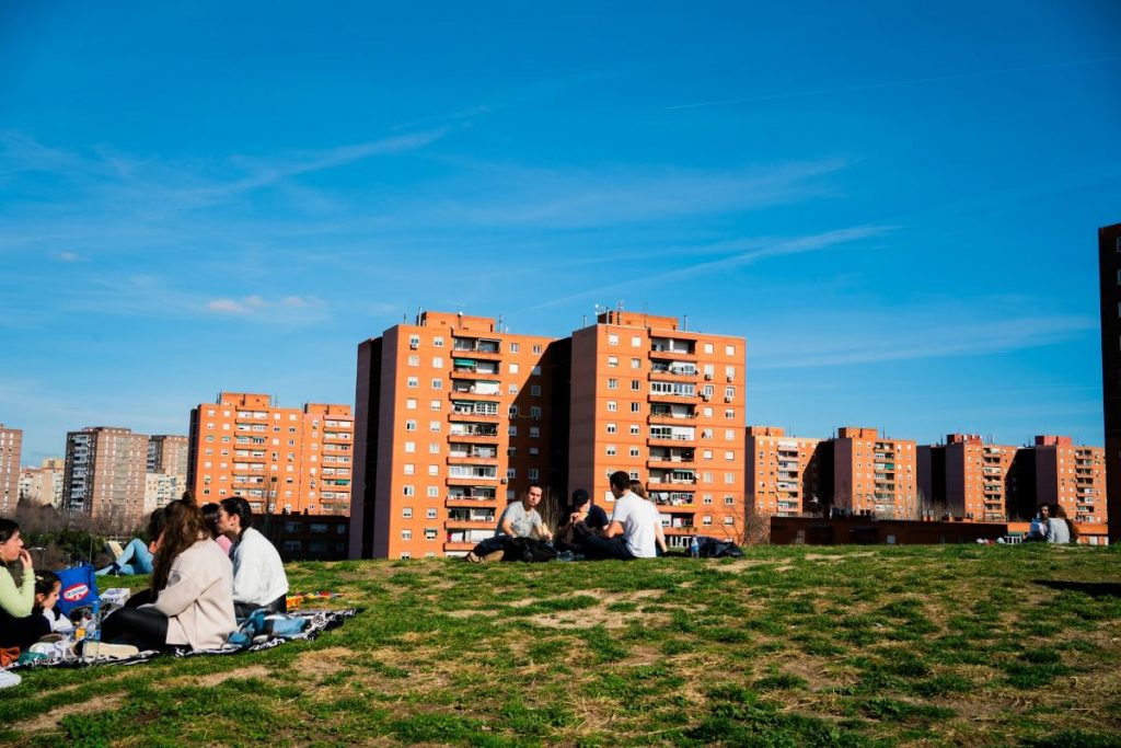 People sitting at Parque de las Siete Tetas in Madrid after learning about different Madrid neighborhood names. 