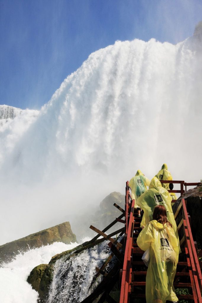 A group of people walking up steps to get views of waterfalls. 