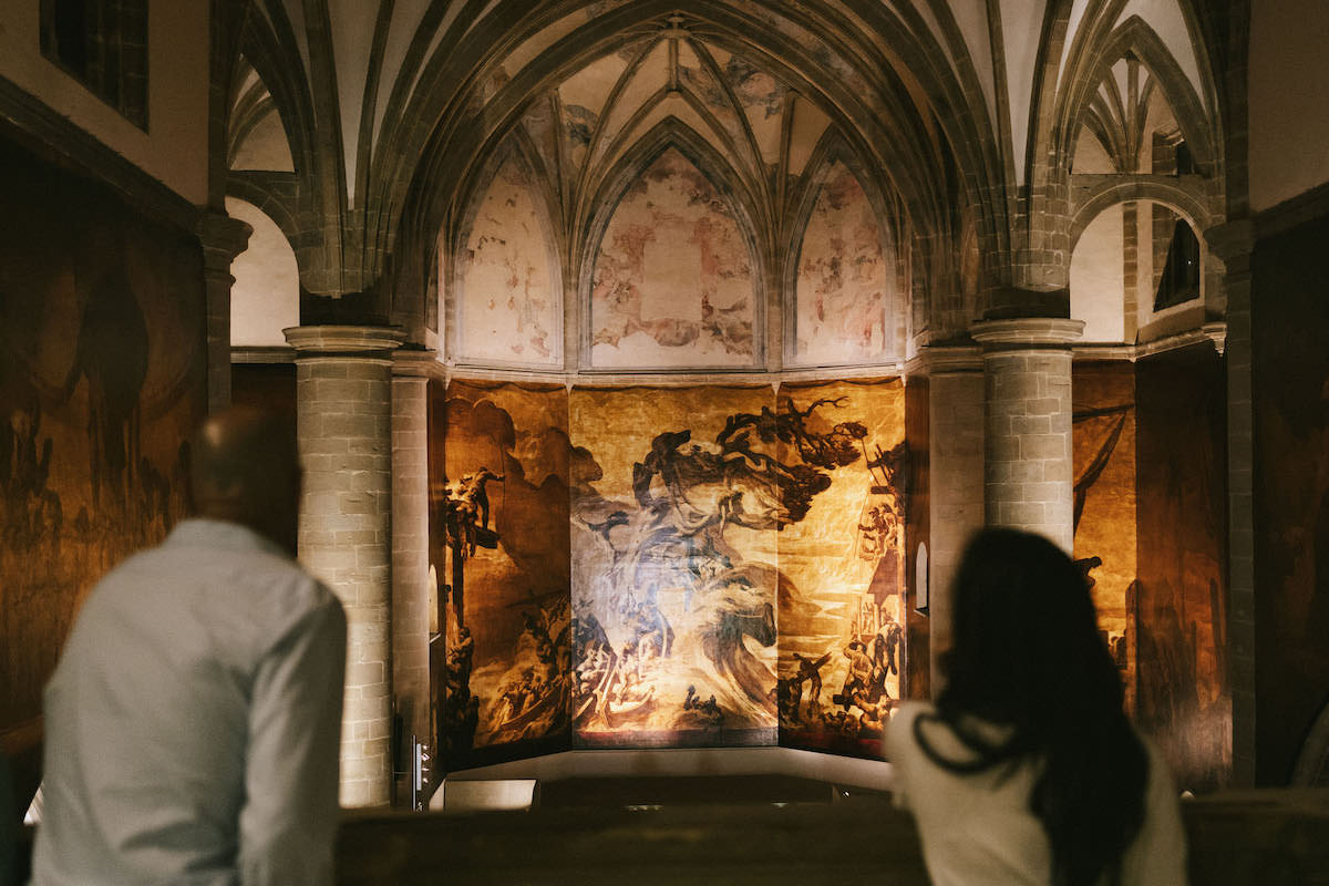 People looking at a painting inside a church