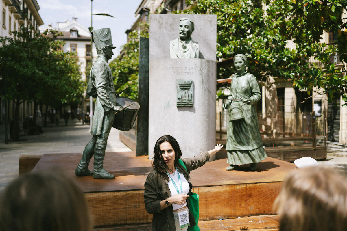 Tour guide explaining sculptures in San Sebastian