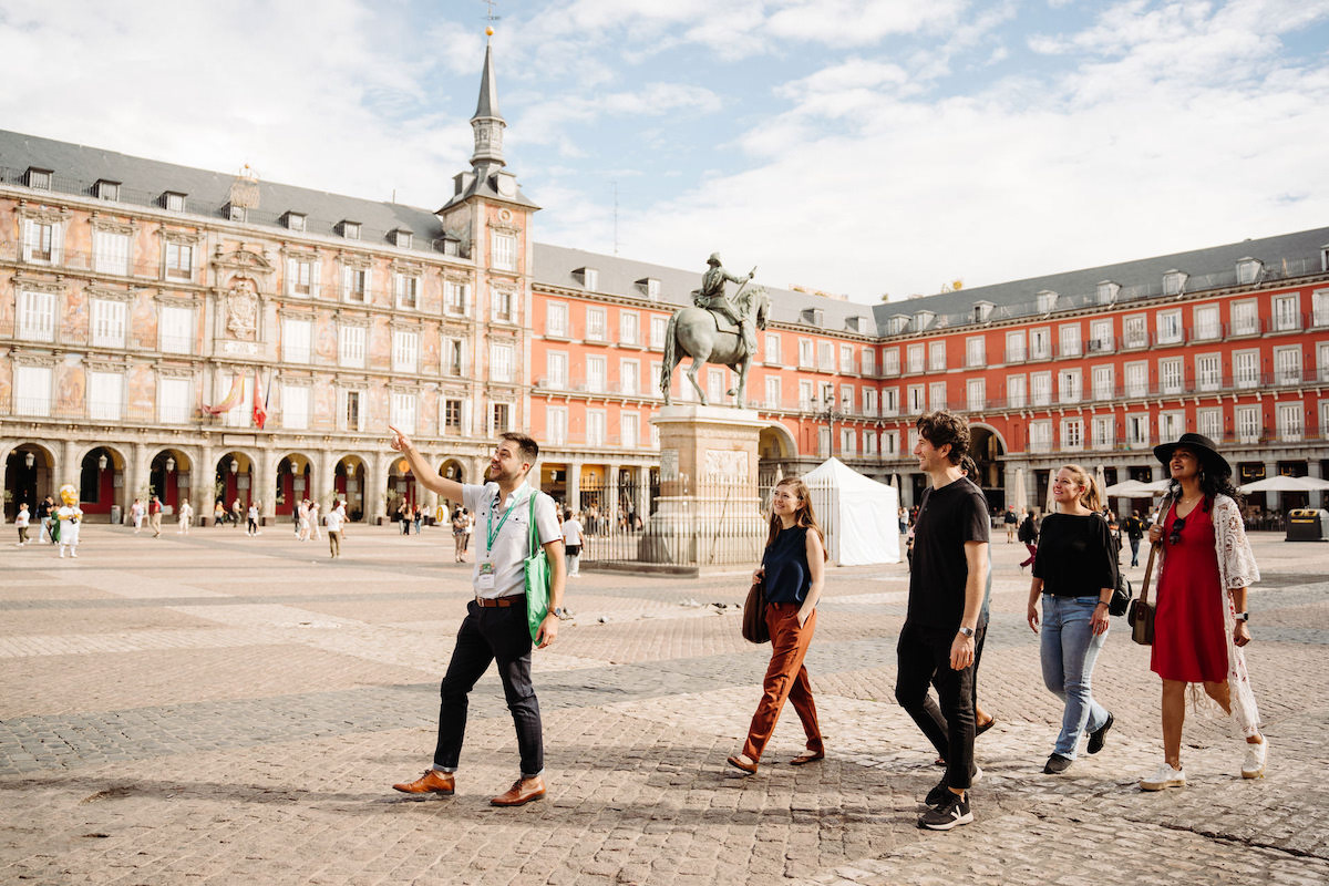 Tour guide with group in Plaza Mayor Madrid on a sunny day