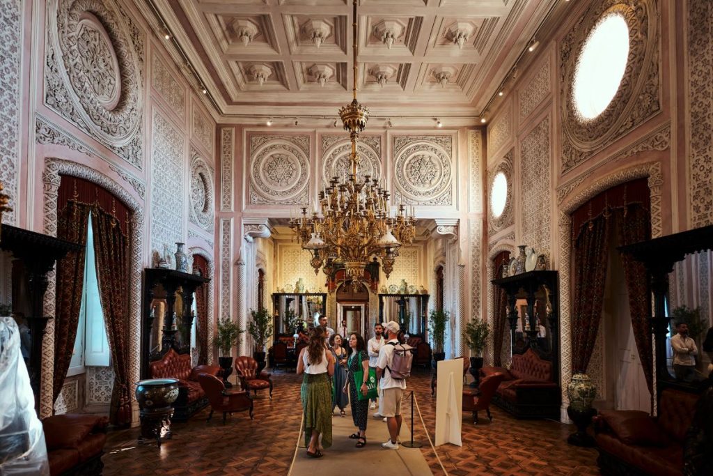 A group of people standing inside Pena Palace looking at the different rooms.