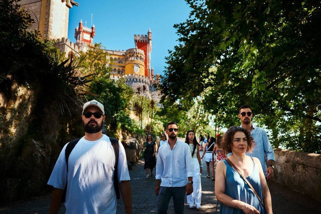 A group of people walking around the palace grounds. 