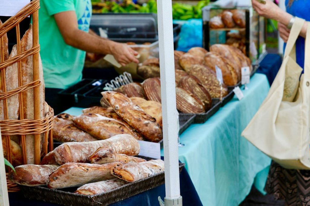 A man selling bread at a farmer's market. 