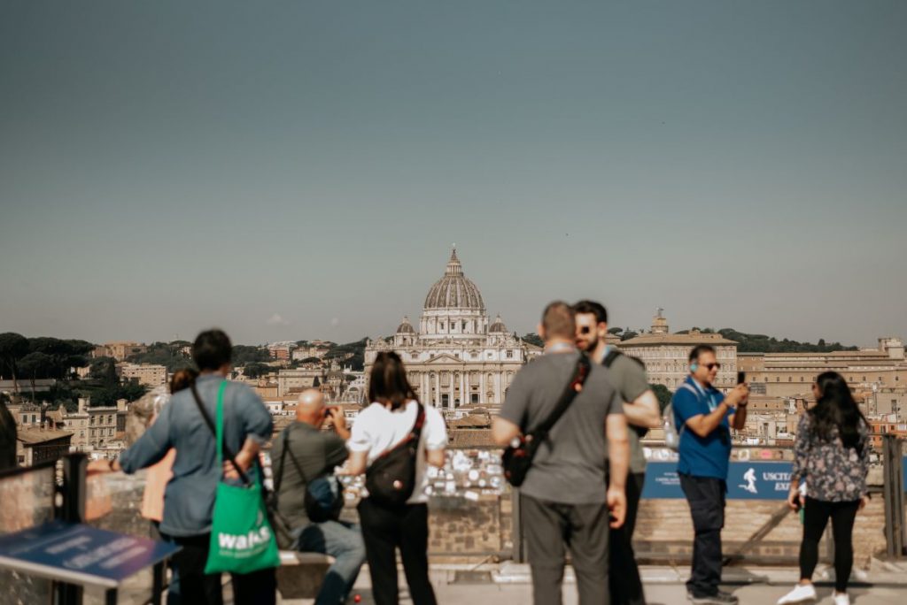 People at a viewpoint taking photos of the Vatican in Rome. 